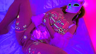Lilykoti, the neon-glowing masked hottie with massive tits, masturbates wildly with anime moans.